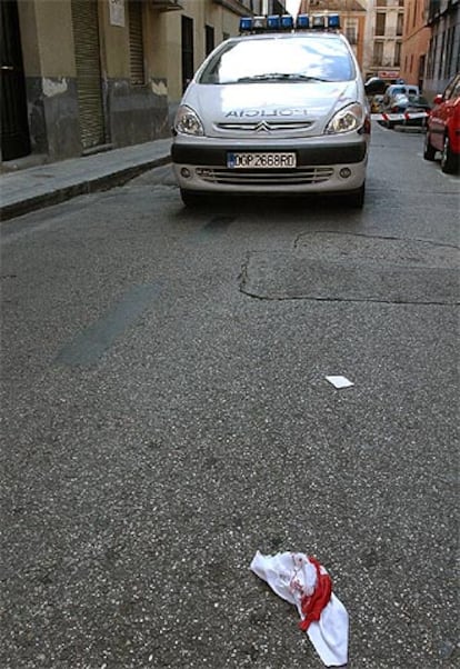 Un pañuelo ensangrentado ante un coche de la Policía en el lugar del suceso, entre las calles de Virtudes y Morejón.