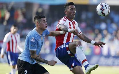 José Giménez, de Uruguay, marca al delantero paraguayo Lucas Barrios.