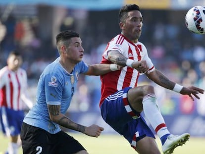 José Giménez, do Uruguai, marca o atacante paraguaio Lucas Barrios.