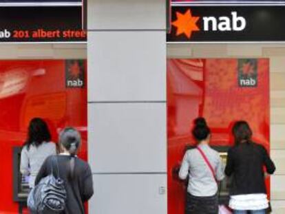 Varias personas sacan dinero de un cajero del Banco Nacional de Australia. EFE/Archivo