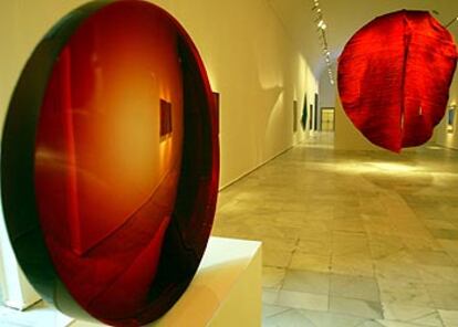 Una vista del entorno cromático del rojo de<i> Monocromos,</i> con<i> Lente roja</i> (1985), de Eversley, en primer término, y <i>Abakan rojo,</i> de Abakanowicz (1969), al fondo.