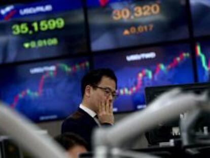 Un inversor permanece junto a varias pantallas que muestran el valor del índice Kospi en Seúl (Corea del Sur).