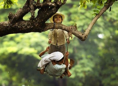 Dos ni&ntilde;os se columpian en la rama de un &aacute;rbol en Usulutan, en El Salvador. Las autoridades del pa&iacute;s consideran que m&aacute;s de 40.000 campesinos, la mayor&iacute;a de ellos cultivadores de ma&iacute;z, se han visto afectados por la sequ&iacute;a este a&ntilde;o. 