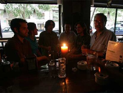 Clientes de un bar de Argüelles toman unas consumiciones a la luz de una vela.