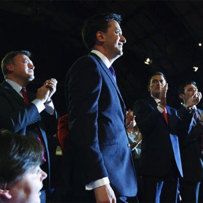 Ed Miliband se dirige a sus seguidores mientras es aplaudido por su hermano David (a la derecha), ayer en Manchester.