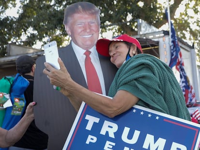 Una mujer se toma una foto con un cartel de Donald Trump en Orlando, Florida, este lunes.