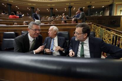 El ministro de Justicia, Alberto Ruiz-Gallardón, el de Exteriores, José Manuel García Margallo, y el presidente del Gobierno, Mariano Rajoy, en su escaño.