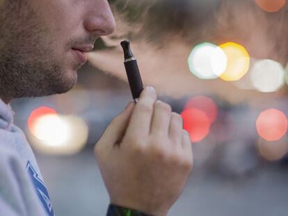 Un hombre fuma un cigarrillo electrónico en una calle de Barcelona.