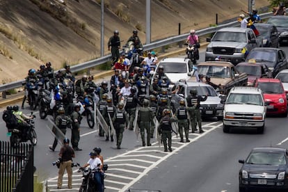 Miembros de la Guardia Nacional Bolivariana (GNB) bloquean el paso a un grupo de personas que participa en la marcha.