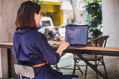 asian woman using laptop outdoor in a cafe