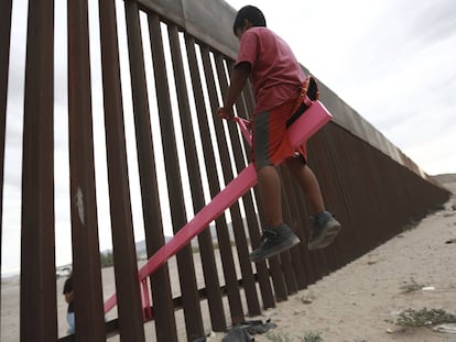 Criança brinca no muro em Ciudad Juárez.