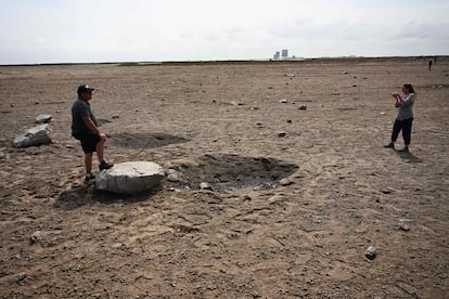 Unos curiosos fotografían un bloque de cemento arrancado desde la plataforma de SpaceX en Boca Chica, Texas.
