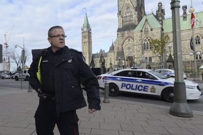 Un oficial de policía resguarda la fachada principal del Parlamento canadiense, hacia donde se sospecha escapó el presunto autor del tiroteo.