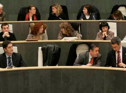 Olano (primero por la derecha en primera fila), conversa  con el diputado de EA Iñaki Galdos durante el pleno. El primero por la izquierda es el titular de Hacienda, Pello González.