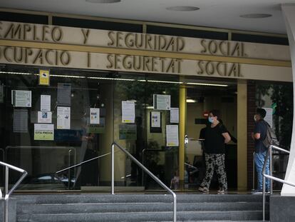 Varias personas esperan en las puertas de la oficina de Empleo y Seguridad Social de Barcelona.