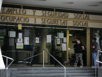 Varias personas esperan en las puertas de la oficina de Empleo y Seguridad Social de Barcelona.