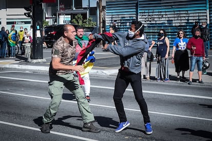 Simpatizante do presidente Bolsonaro segura a bandeira rubro-negra do grupo de extrema-direita ucraniano 'Pravyi Sektor' durante protesto em São Paulo.