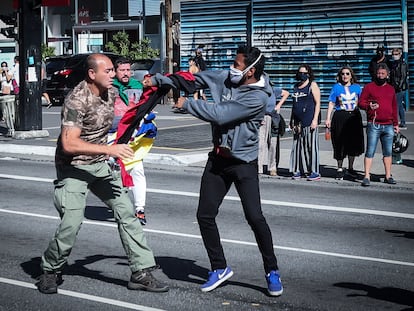 Simpatizante do presidente Bolsonaro segura a bandeira rubro-negra do grupo de extrema-direita ucraniano 'Pravyi Sektor' durante protesto em São Paulo.