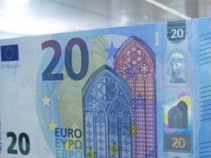 Un hombre fotografía el nuevo billete de 20 euros en el Banco Central Europeo (BCE), en Fráncfort (Alemania).