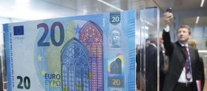 Un hombre fotografía el nuevo billete de 20 euros en el Banco Central Europeo (BCE), en Fráncfort (Alemania).