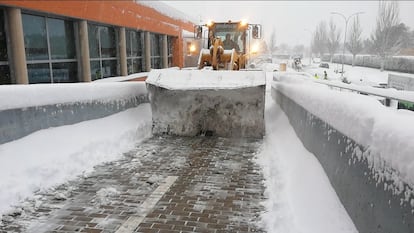 Una excavadora municipal limpia los accesos del hospital de Alcalá de Henares. 