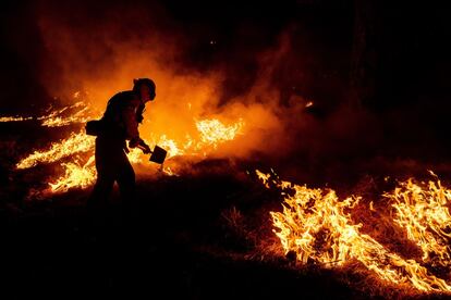 Un bombero trabaja para contener el progreso del incendio Bobcat al norte de Monrovia (California), el viernes.