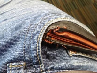 Una cartera asoma del bolsillo de un pantal&oacute;n.