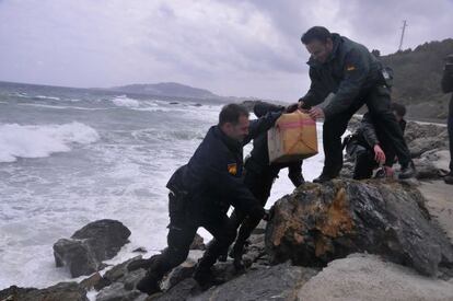 Civil Guard officers take one of the hashish packages out of the sea on Monday.