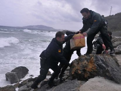Varios guardias civiles sacan el lunes del mar uno de los fardos.