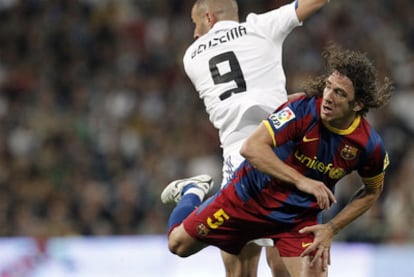Puyol pelea por el balón con Benzema en el último clásico liguero.