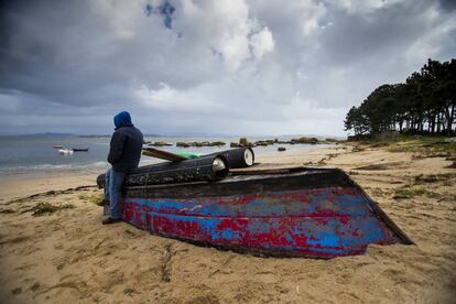 A poacher on the Arousa estuary leans on a boat used for the nightly raids. 