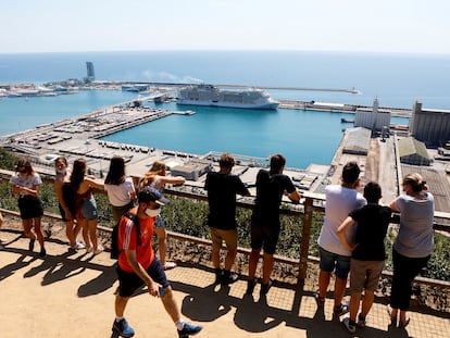 Turistas observando el MSC Grandiosa, atracado en el Puerto de Barcelona.