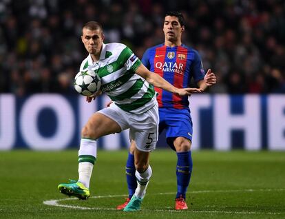 Jozo Simunovic del Celtic (izquierda) controla el balón ante Luis Suárez de FC Barcelona.