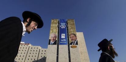 Dos ultraortodoxos pasan por delante de un cartel electoral de Benjamin Netanyahu y Avigdor Lieberman en Jerusalén.