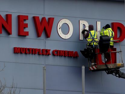 Dos operarios reparan el cartel de una sala Cineworld en Bradford (norte de Inglaterra), en marzo de 2016.