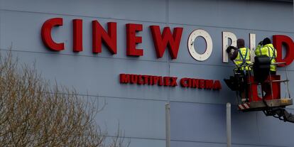 Dos operarios reparan el cartel de una sala Cineworld en Bradford (norte de Inglaterra), en marzo de 2016.