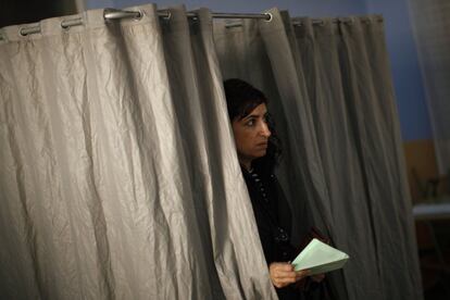 Una mujer sale de la cabina para ejercer su derecho al voto en Ronda, Málaga.