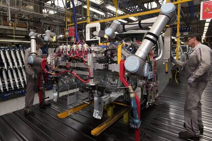 Dos empleados trabajando en la fabricación de un coche en la planta de PSA en Vigo.