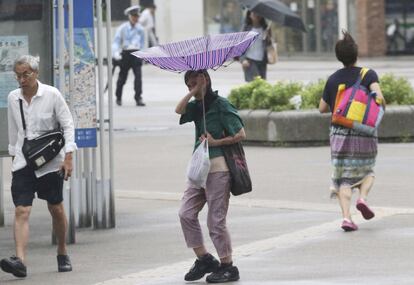 Uma pessoa tenta sustentar seu guarda-chuva em meio aos fortes ventos em Yokohama (Japão).