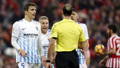 Jugadores del Málaga protestan al árbitro por un penalti pitado a favor del Athletic de Bilbao en San Mamés.