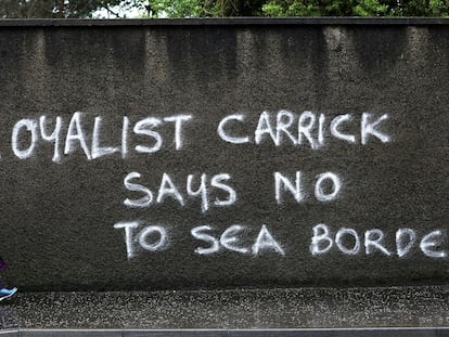 Una mujer pasa ante una pintada en contra de los controles aduaneros en el mar de Irlanda, en Carrickfergus (Irlanda del Norte).