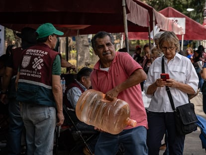 Trabajadores de la alcaldía Benito Juárez reparten garrafones de agua a los vecinos afectados por el agua contaminada.