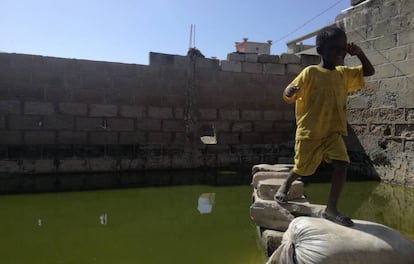 El pequeño Malick vuelve del baño en la daara de Mohamed Sow, inundada tras las lluvias.