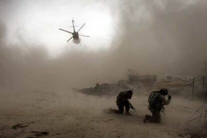 Soldados estadounidenses se protegen de la arena levantada por un helicóptero en Kandahar.