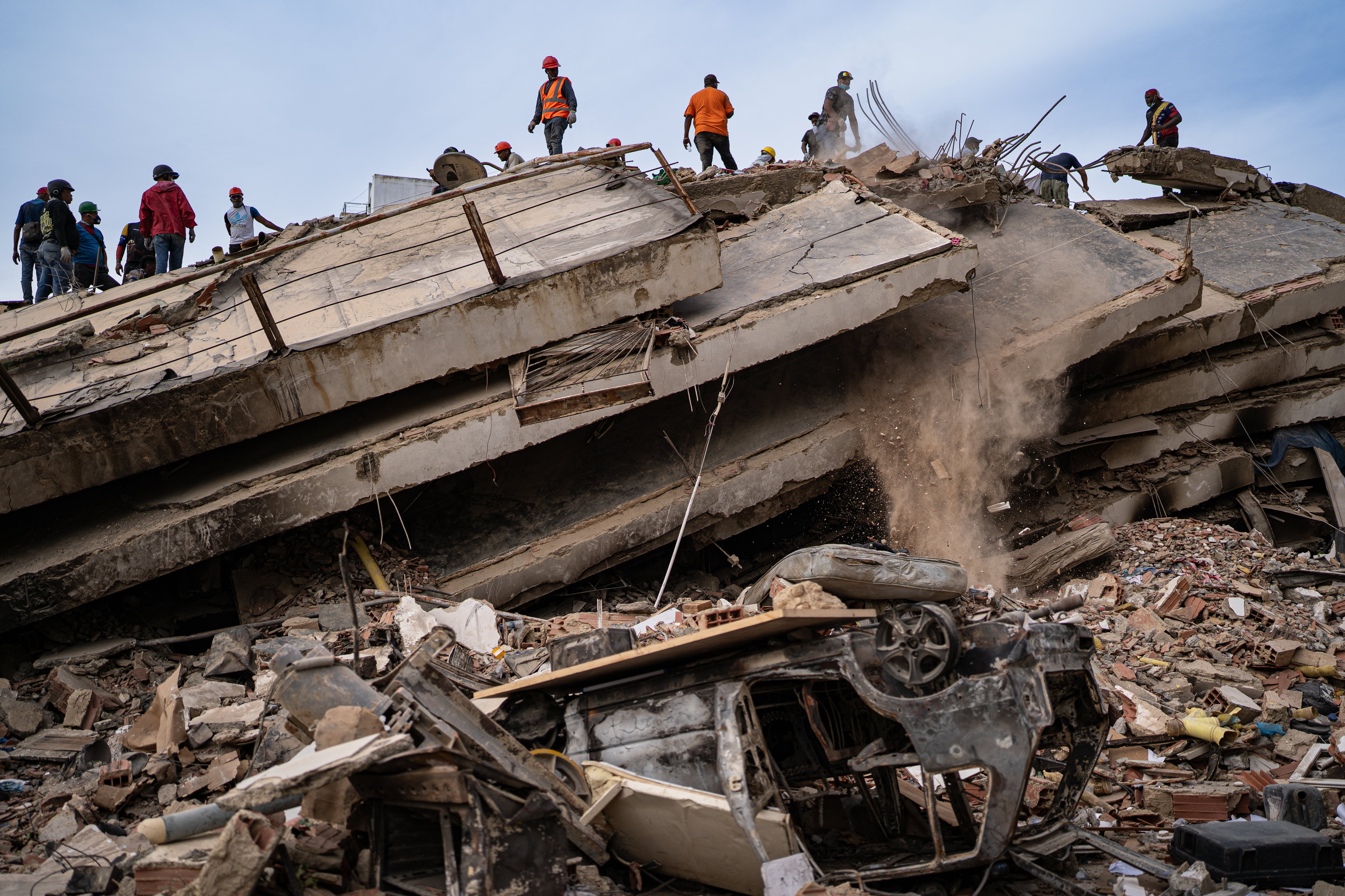 Rescatistas trabajan en remover escombros en busca de víctimas del terremoto, en La Guaira.