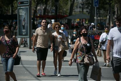 Varias personas con y sin mascarilla en el centro de Barcelona.