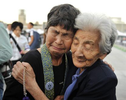 Las supervivientes japonesas Tsuyuki Nakao (a la derecha), de 92 años, y Kinuyo Ikegami, de 77, rezan por las víctimas de la bomba atómica durante la ceremonia de conmemoración del 65 aniversario del lanzamiento.
