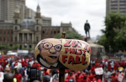 Un manifestante sostiene una calabaza pintada con una imagen del presidente surafricano Jacob Zuma, durante una marcha anti-gobierno a las puertas de la corte de Pretoria (Sudáfrica). Miles de sudafricanos se están manifestando por su resignación con el presidente Jacob Zuma, que ha estado envuelto en escándalos que los críticos —sostienen— están socavando la democracia del país.