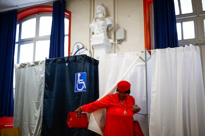 Una mujer sale de una cabina de votación para emitir su voto en la segunda vuelta de las elecciones parlamentarias anticipadas francesas, en un colegio electoral en París.