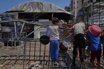 Niños palestinos esperan en un comedor comunitario antes de que se preparen y distribuyan los alimentos donados en la ciudad de Gaza, este viernes.